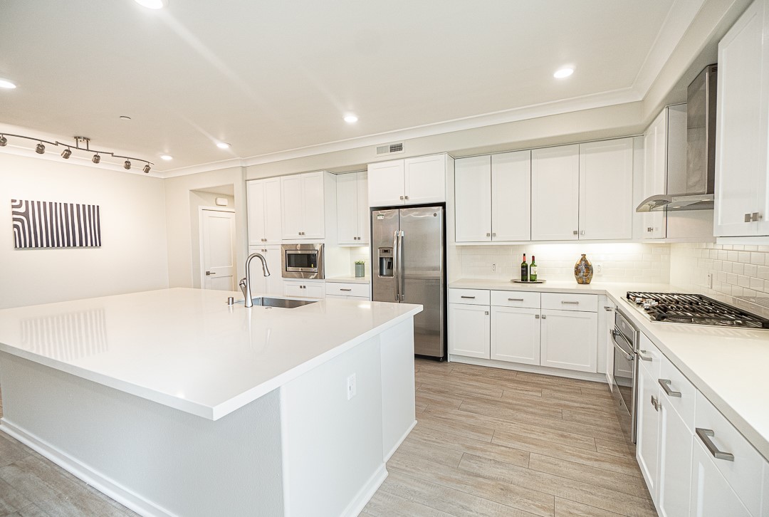 a kitchen with white cabinets and white appliances