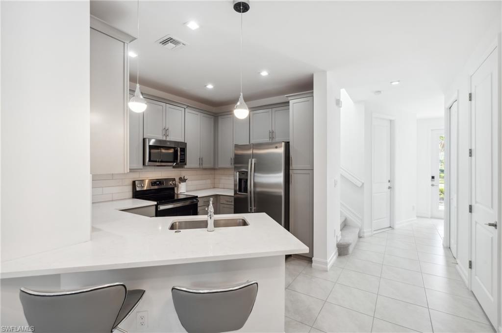 a kitchen with kitchen island a sink appliances and cabinets