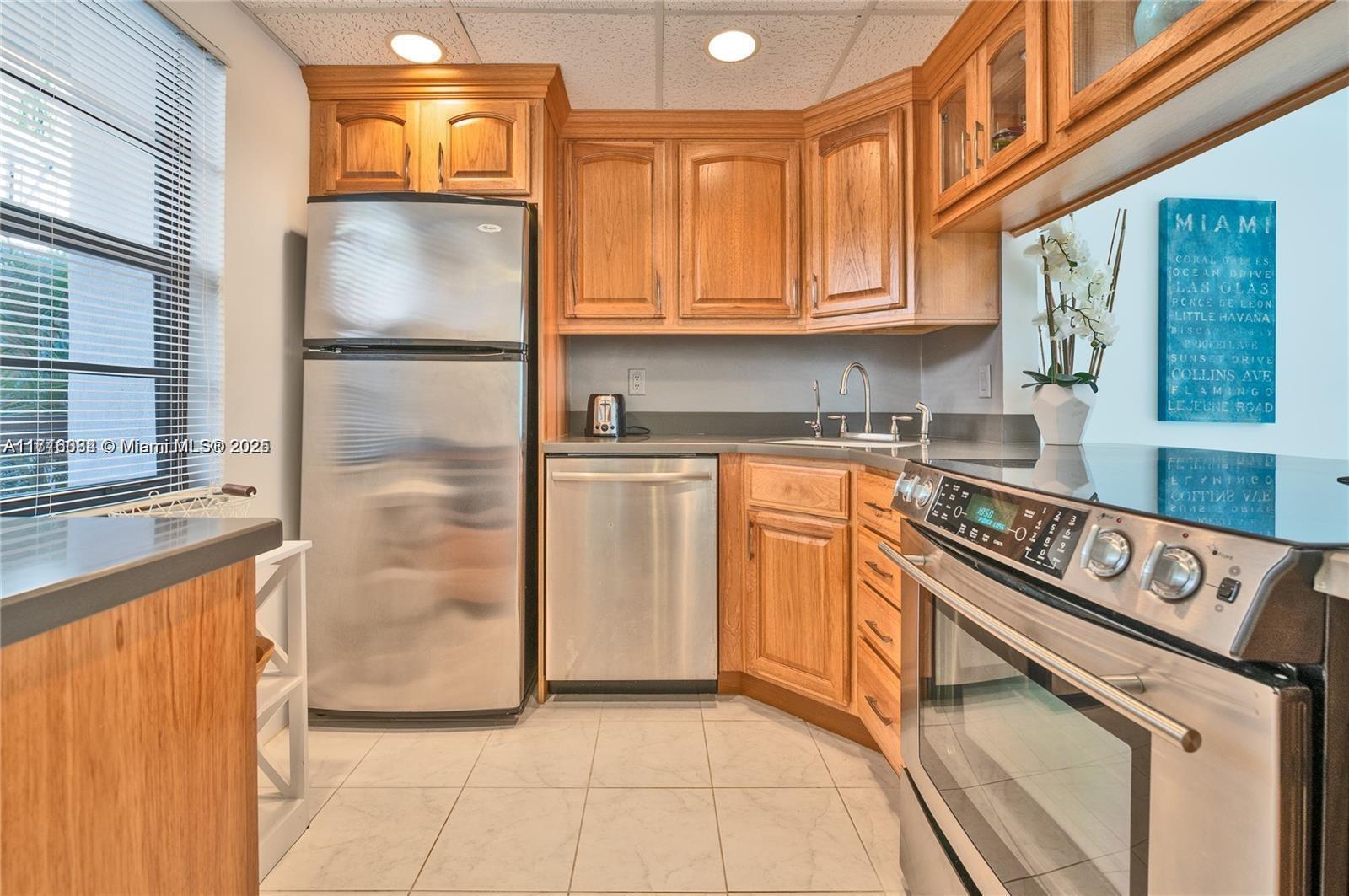 a kitchen with stainless steel appliances granite countertop a refrigerator sink and cabinets