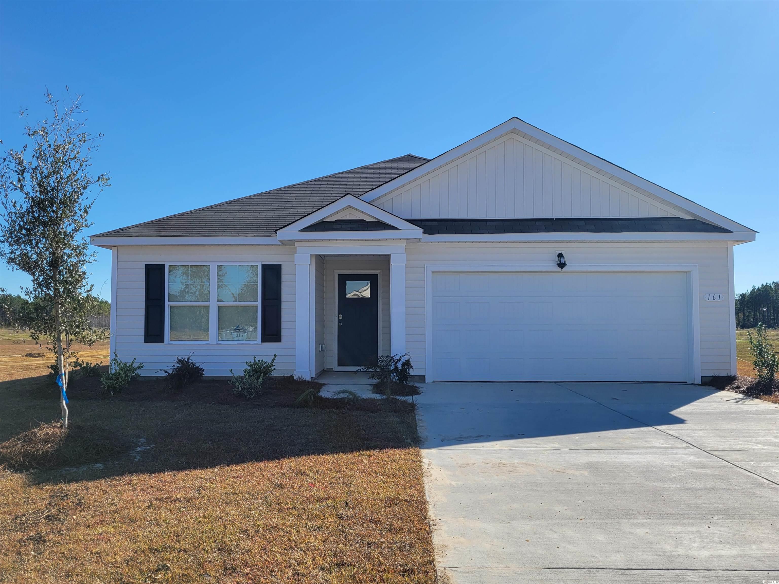 Single story home featuring a front yard and a gar