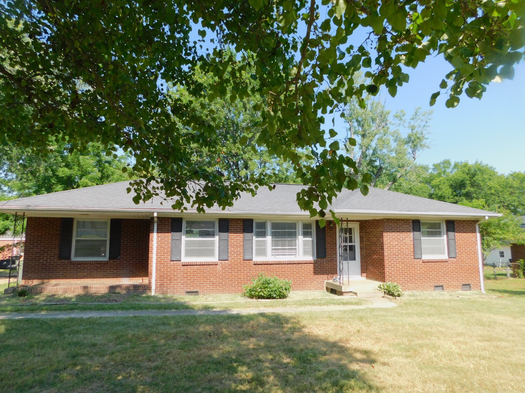 a front view of a house with a yard and trees