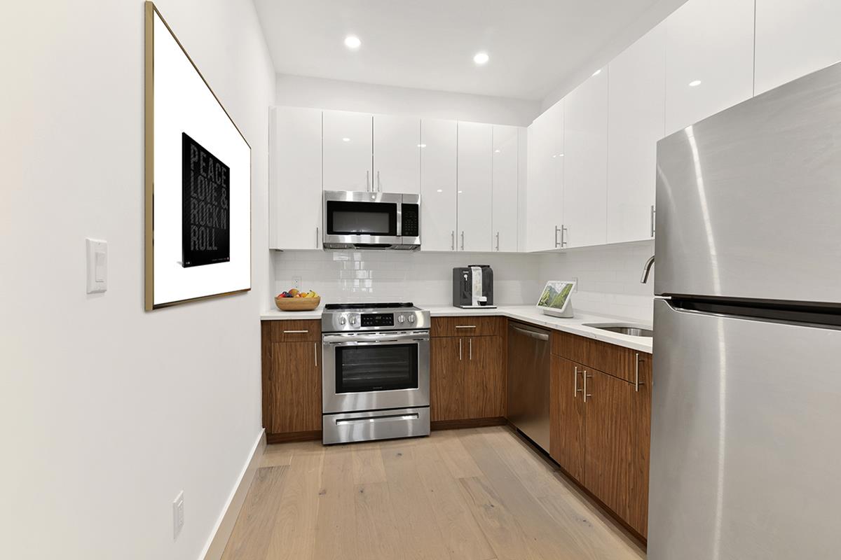 a kitchen with stainless steel appliances a stove sink microwave and refrigerator