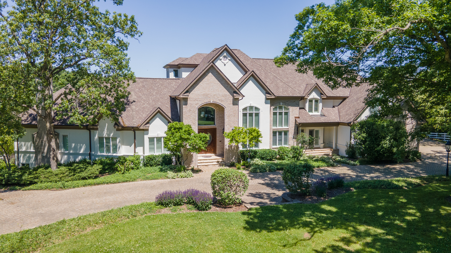 a front view of a house with a yard and potted plants