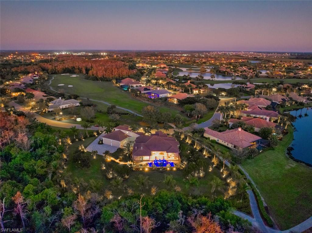 an aerial view of residential houses with outdoor space and trees