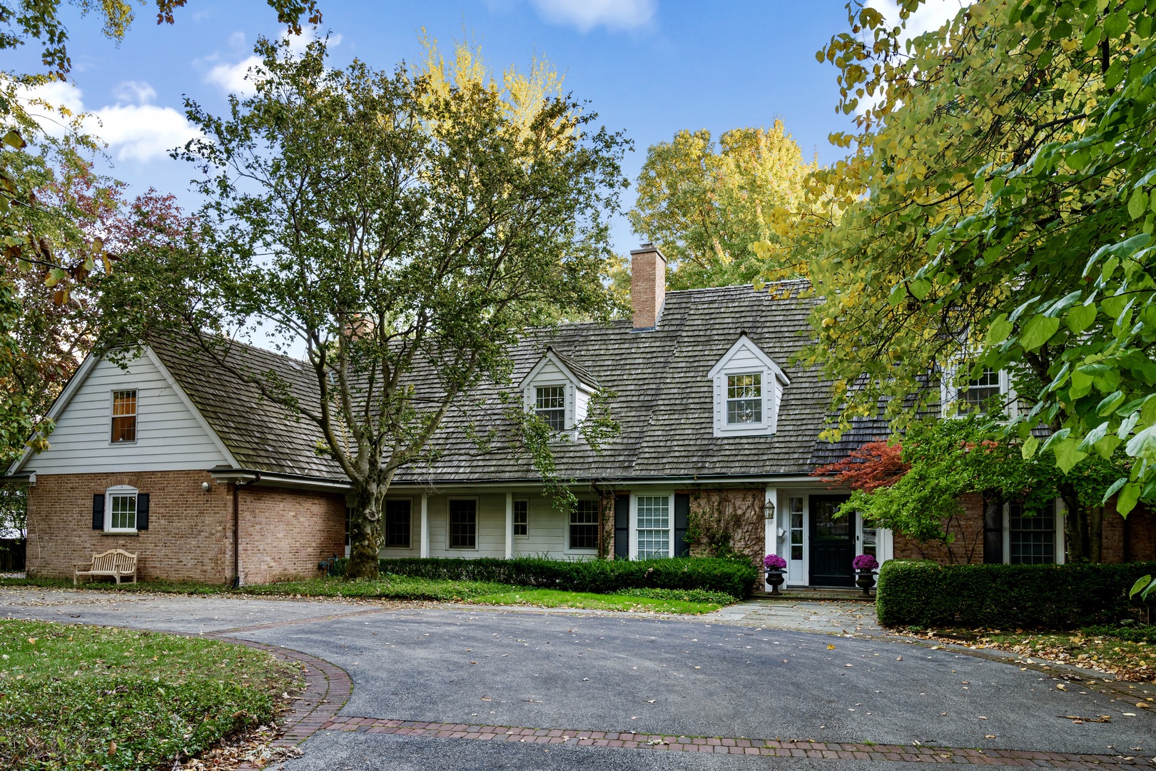 a front view of a house with a yard and potted plants