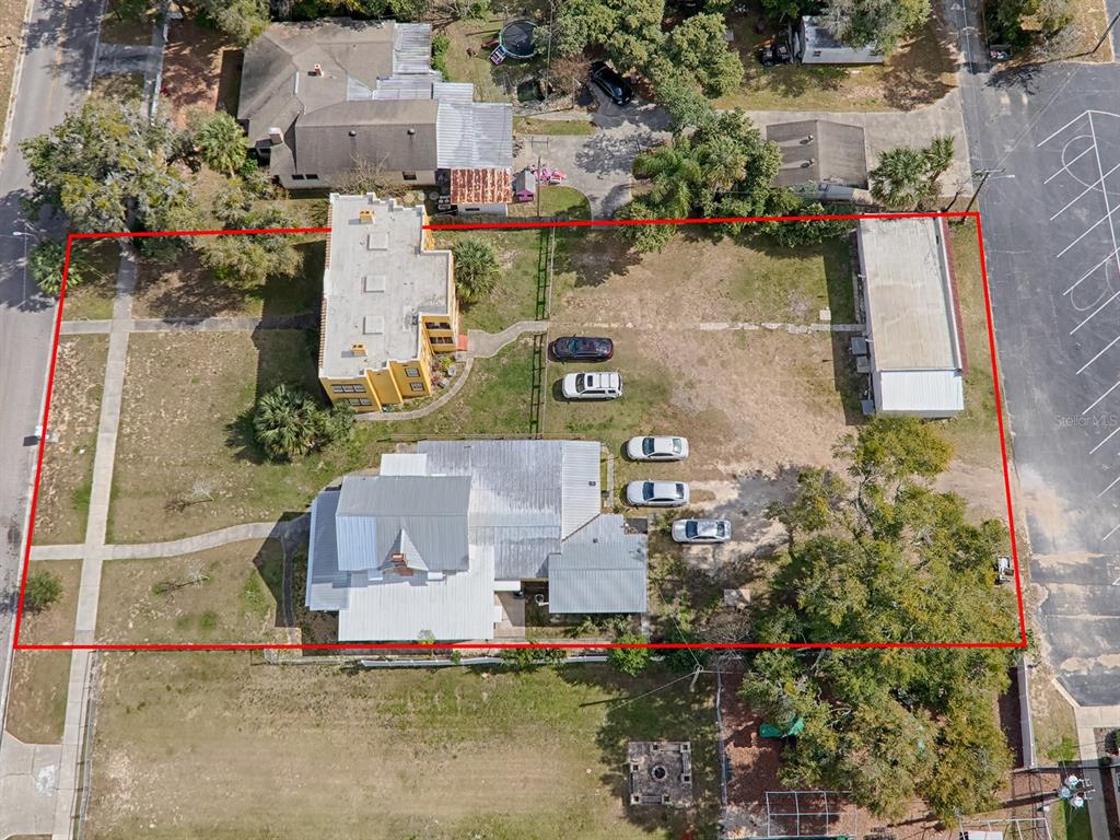 an aerial view of a house with a yard and a large tree