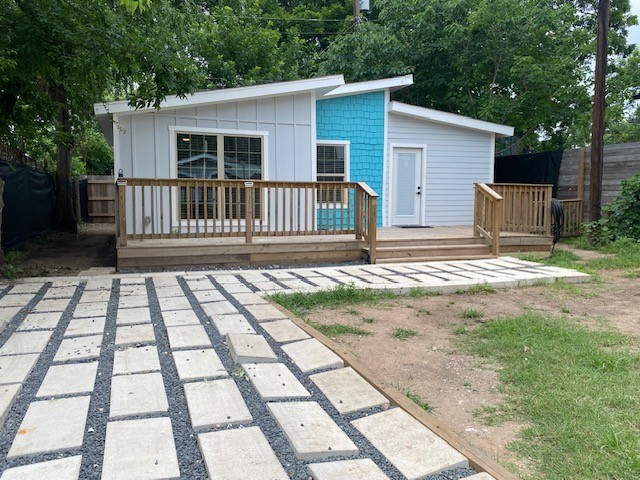 a view of a house with backyard and deck