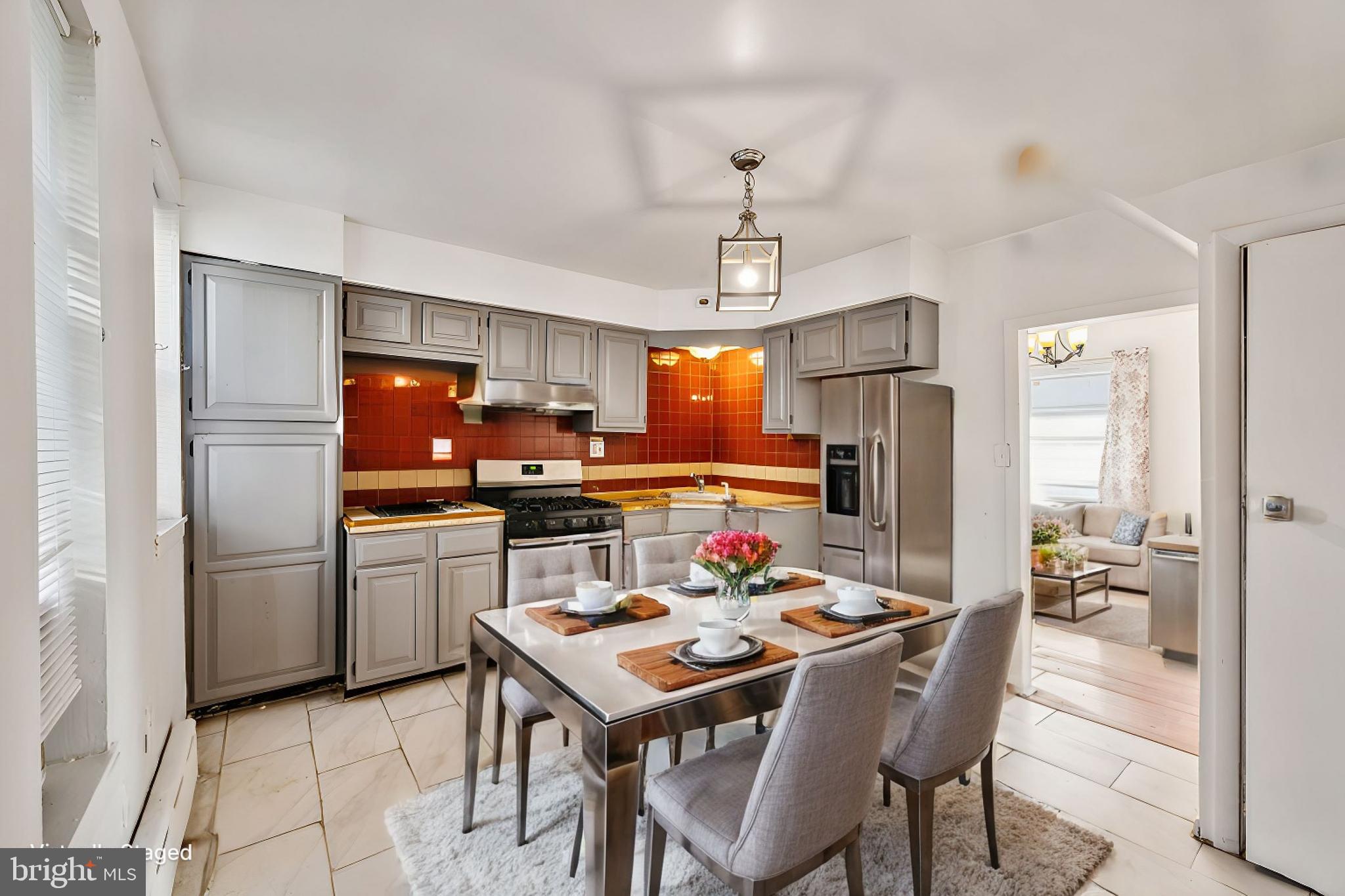 a kitchen with stainless steel appliances a dining table and chairs