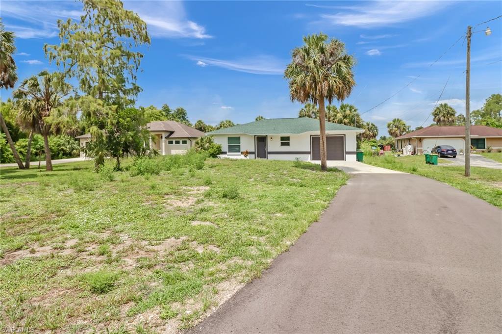 Single story home with a front yard and a garage