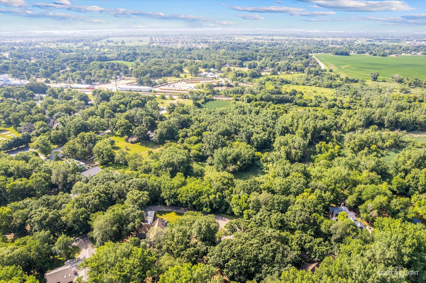 an aerial view of residential houses with outdoor space and trees