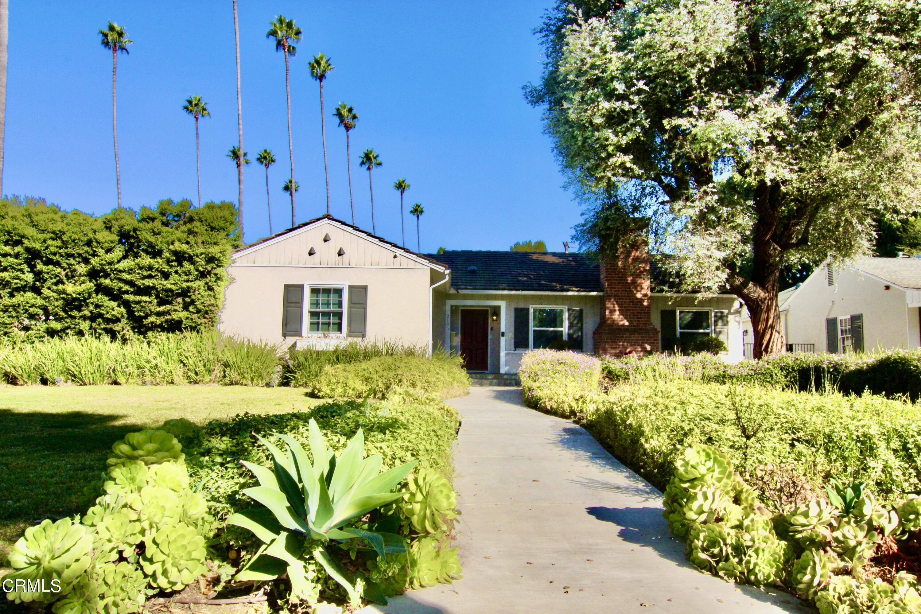 a front view of a house with a yard with flower plants