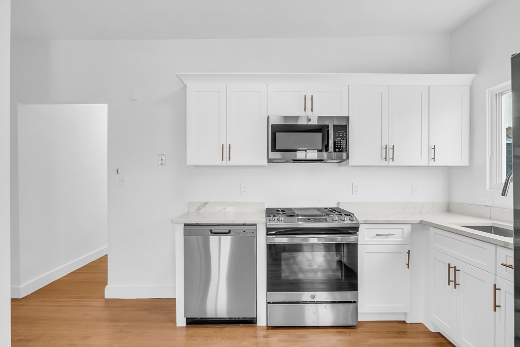 a kitchen with white cabinets and stainless steel appliances