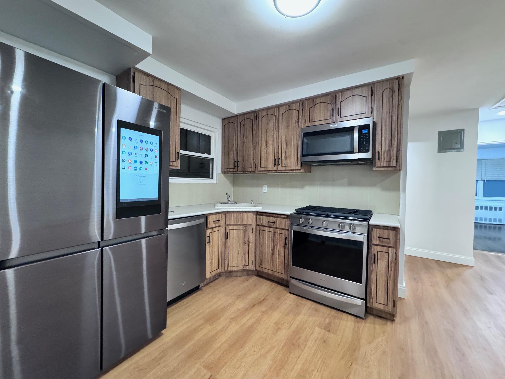 Kitchen with sink, stainless steel appliances, and light hardwood / wood-style floors