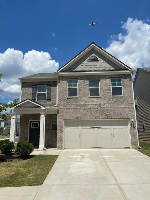 a front view of a house with yard and parking