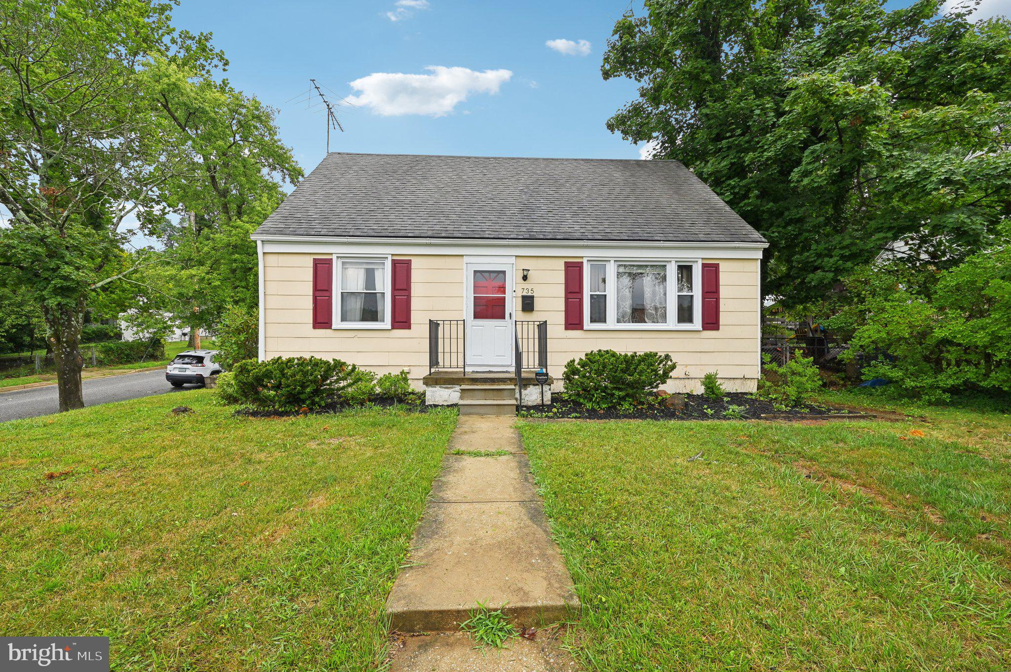 a front view of a house with yard and green space