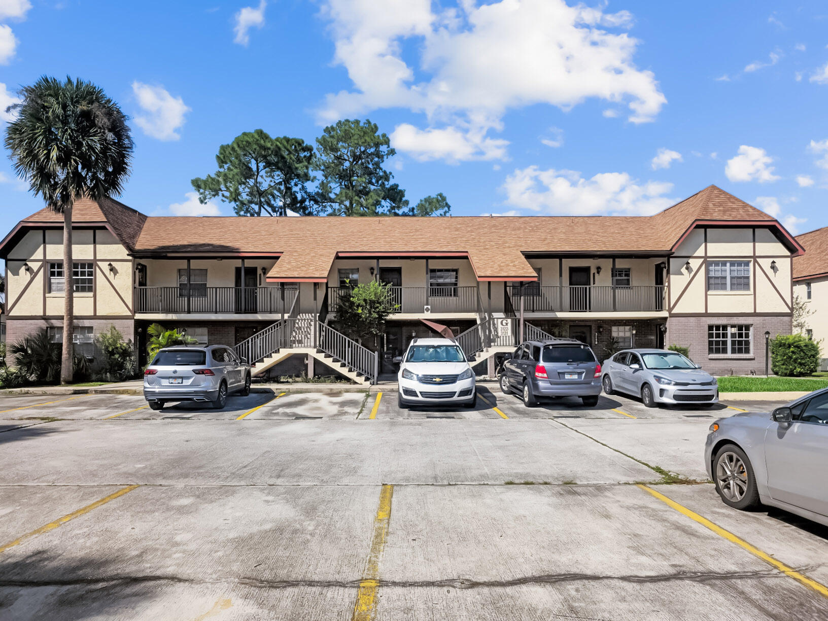 an outdoor view of a cars park in front of a house