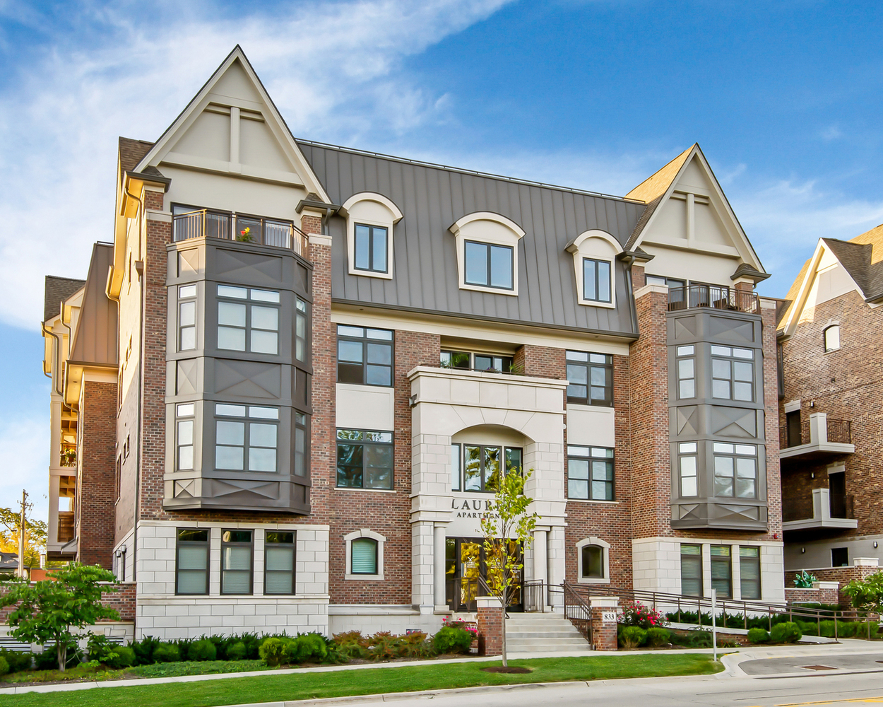 a front view of a residential apartment building with a yard