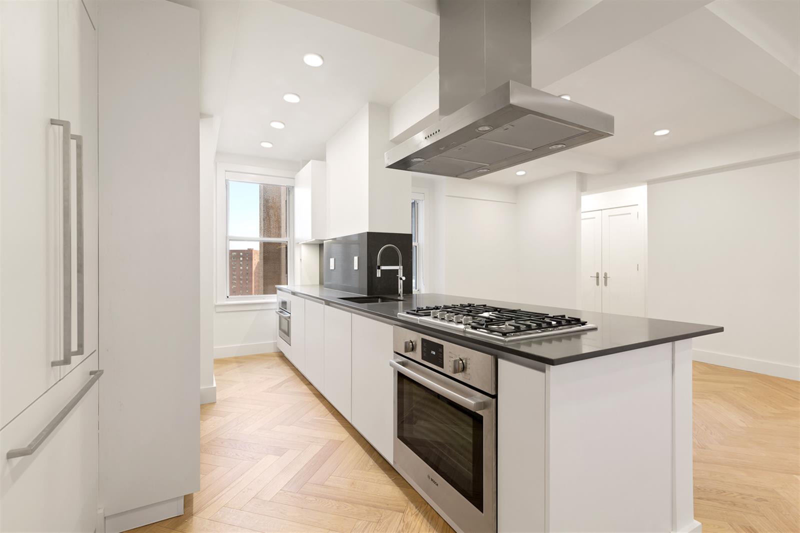 a kitchen with stainless steel appliances a stove a microwave and white cabinets