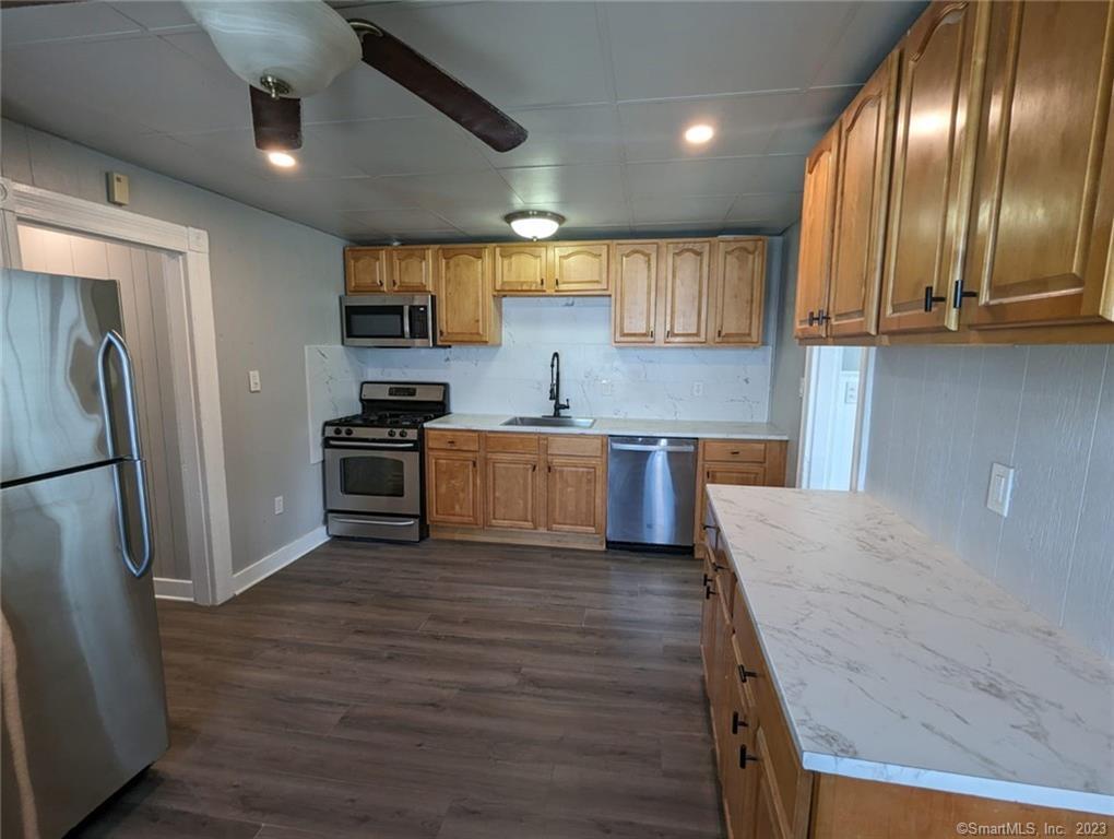 a kitchen with stainless steel appliances granite countertop wooden floors and sink