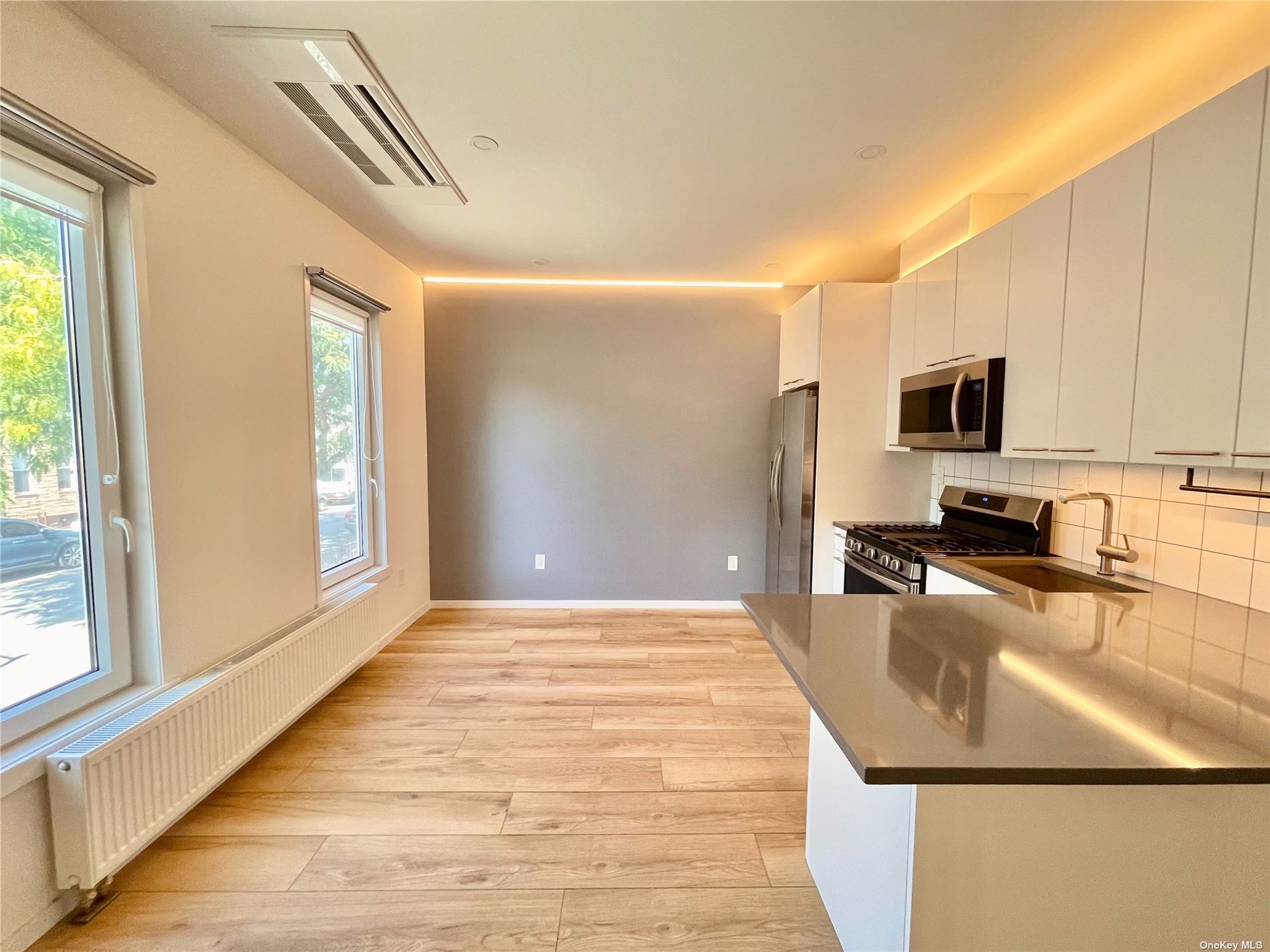 a view of a kitchen with kitchen island a sink wooden floor and counter top space