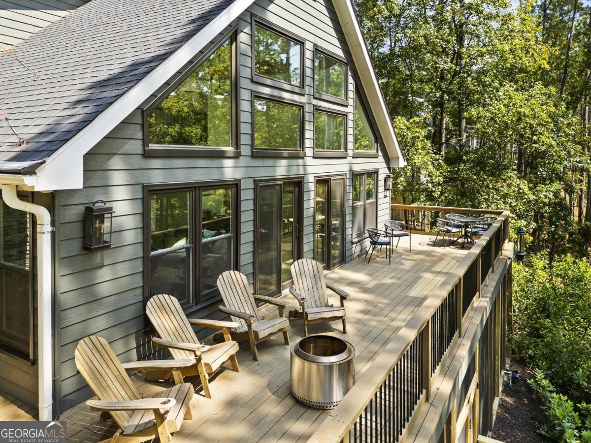 a view of deck with table and chairs and wooden fence