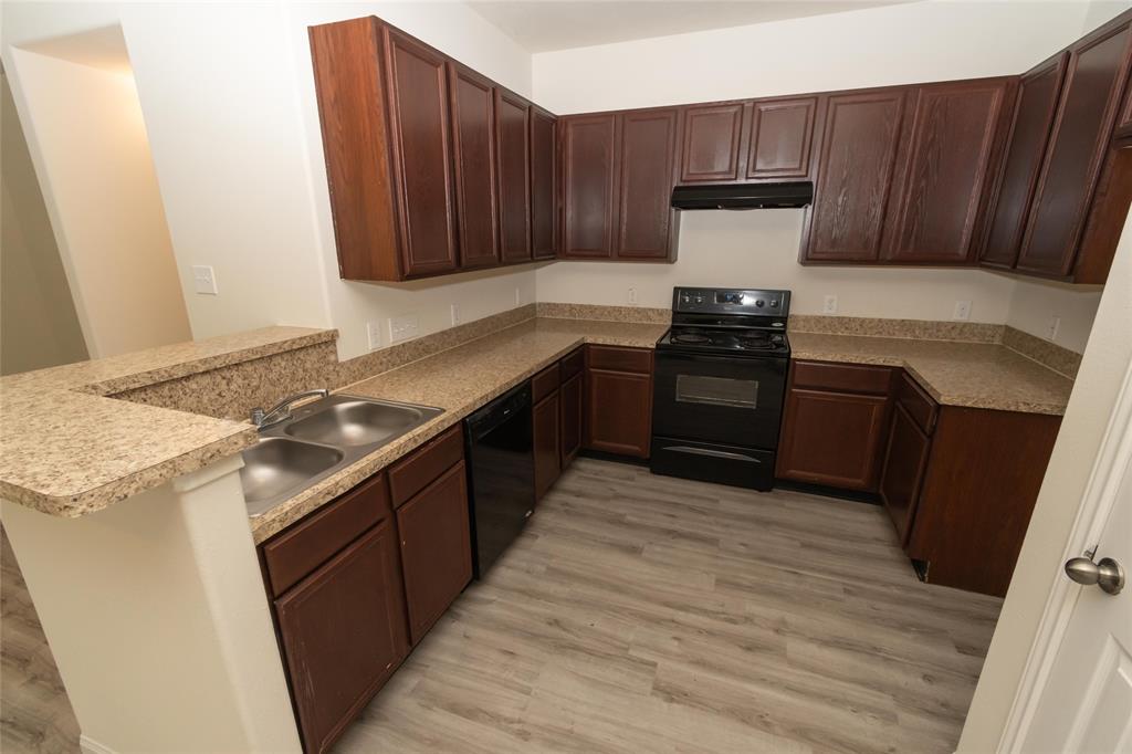 a kitchen with granite countertop wooden cabinets and stainless steel appliances