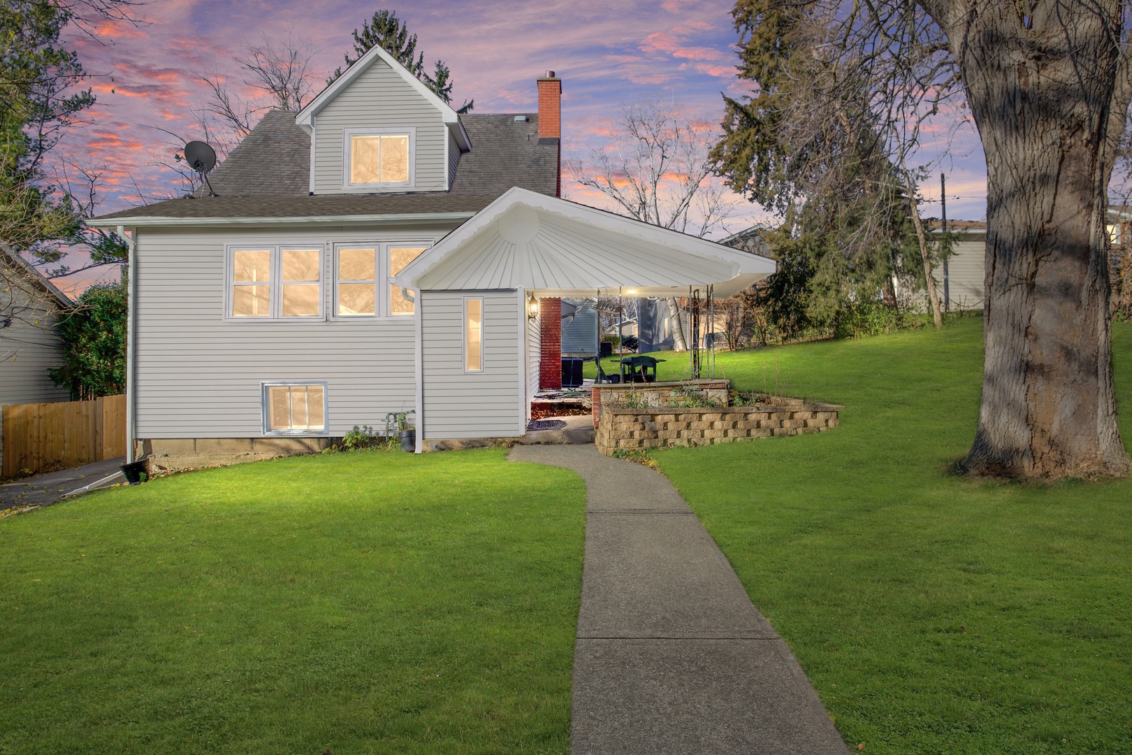 a front view of a house with a garden and plants