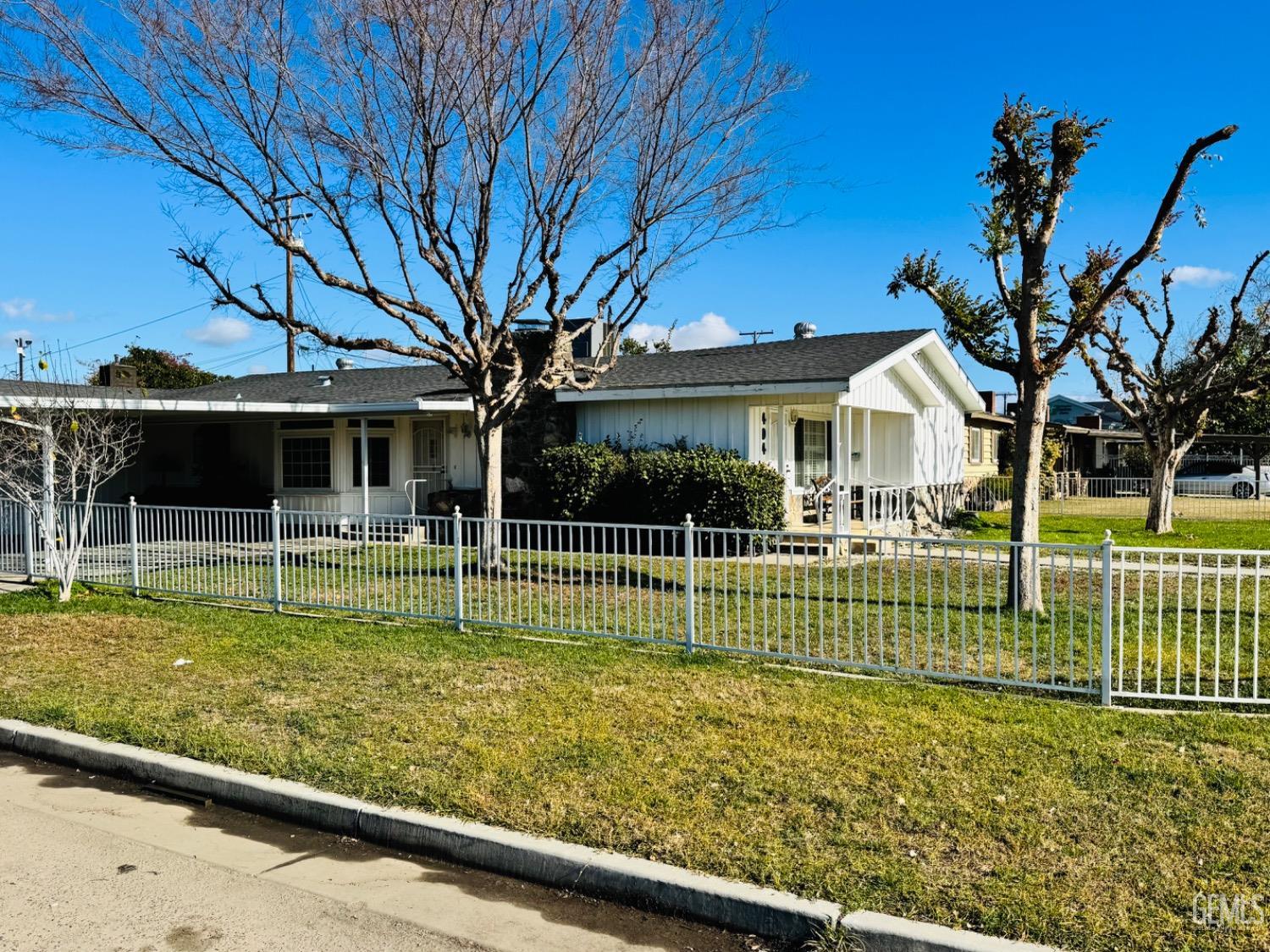 a view of house with a big yard and potted plants