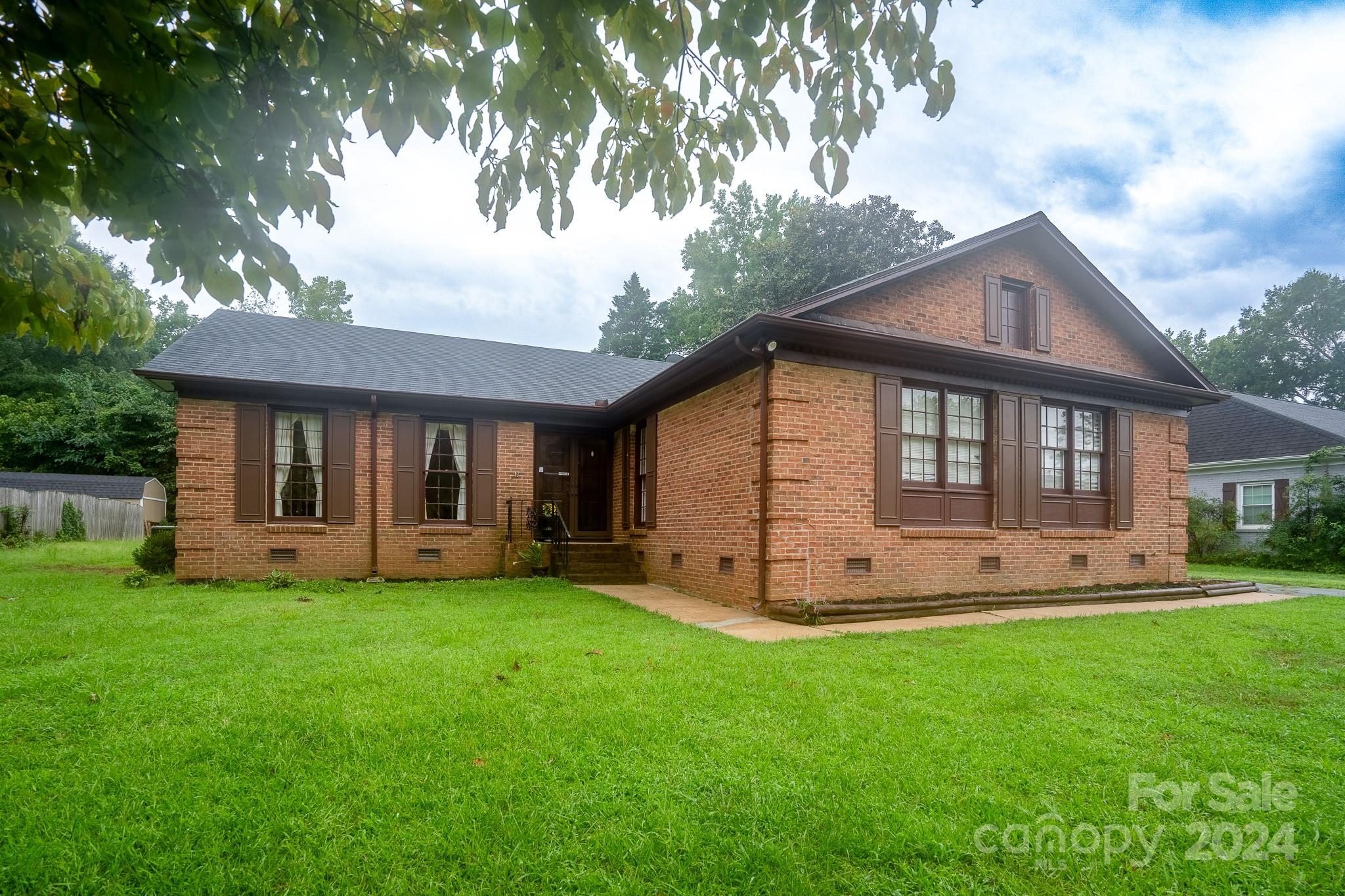 a view of a house with a yard and sitting area