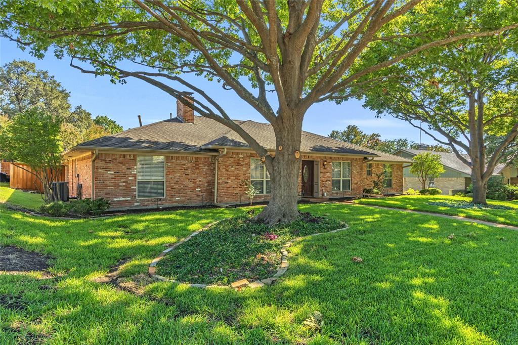 a view of a yard in front of a house with large trees