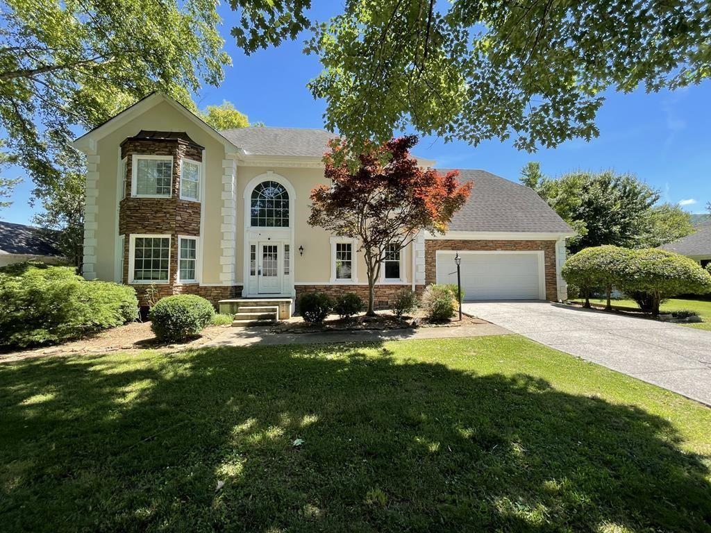 a front view of a house with yard and green space