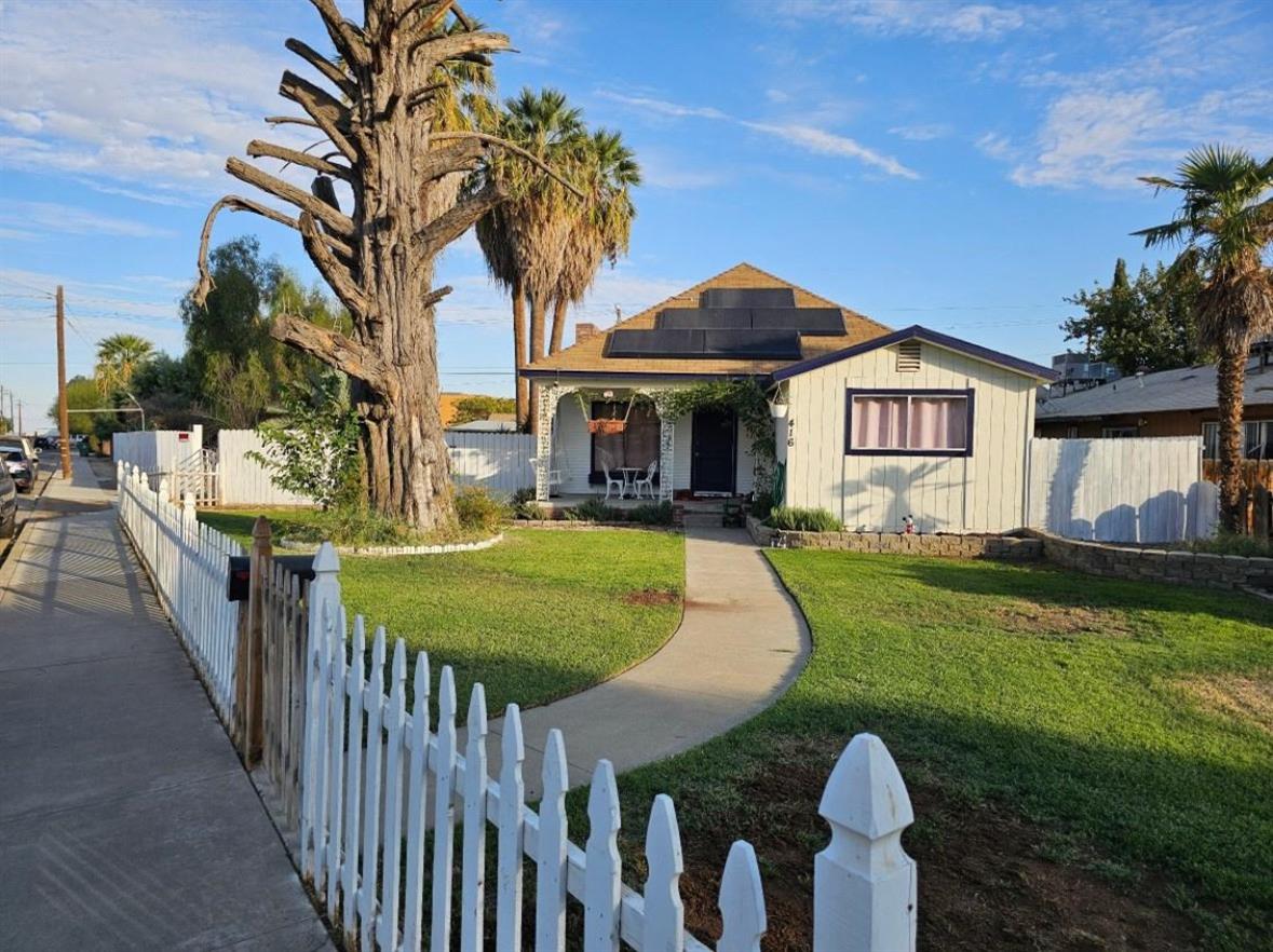 a front view of a house with yard and green space