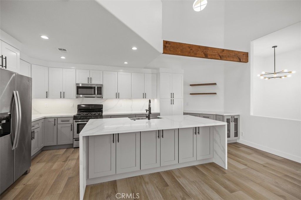 a kitchen with stainless steel appliances a sink cabinets and wooden floor