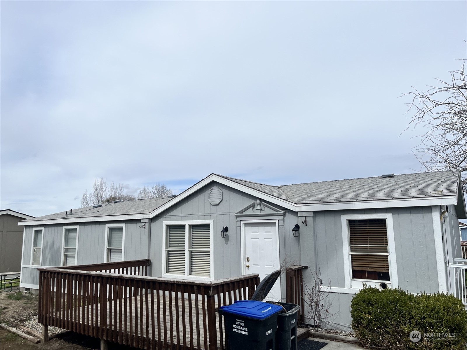 a view of a house with wooden deck and a yard