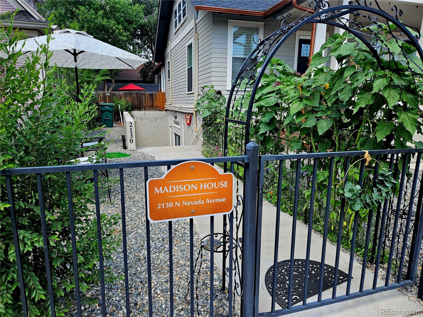 a view of a house with a small yard and sitting area