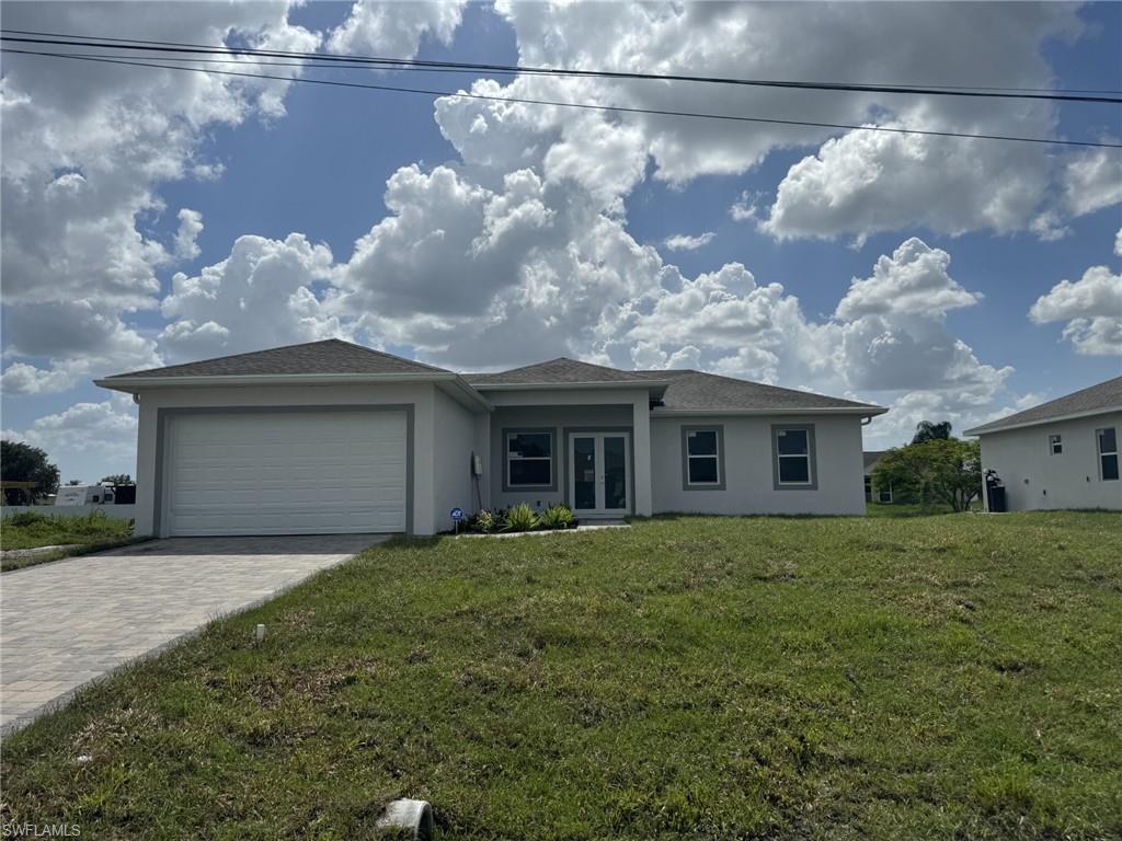 View of front of property with a front lawn and a garage