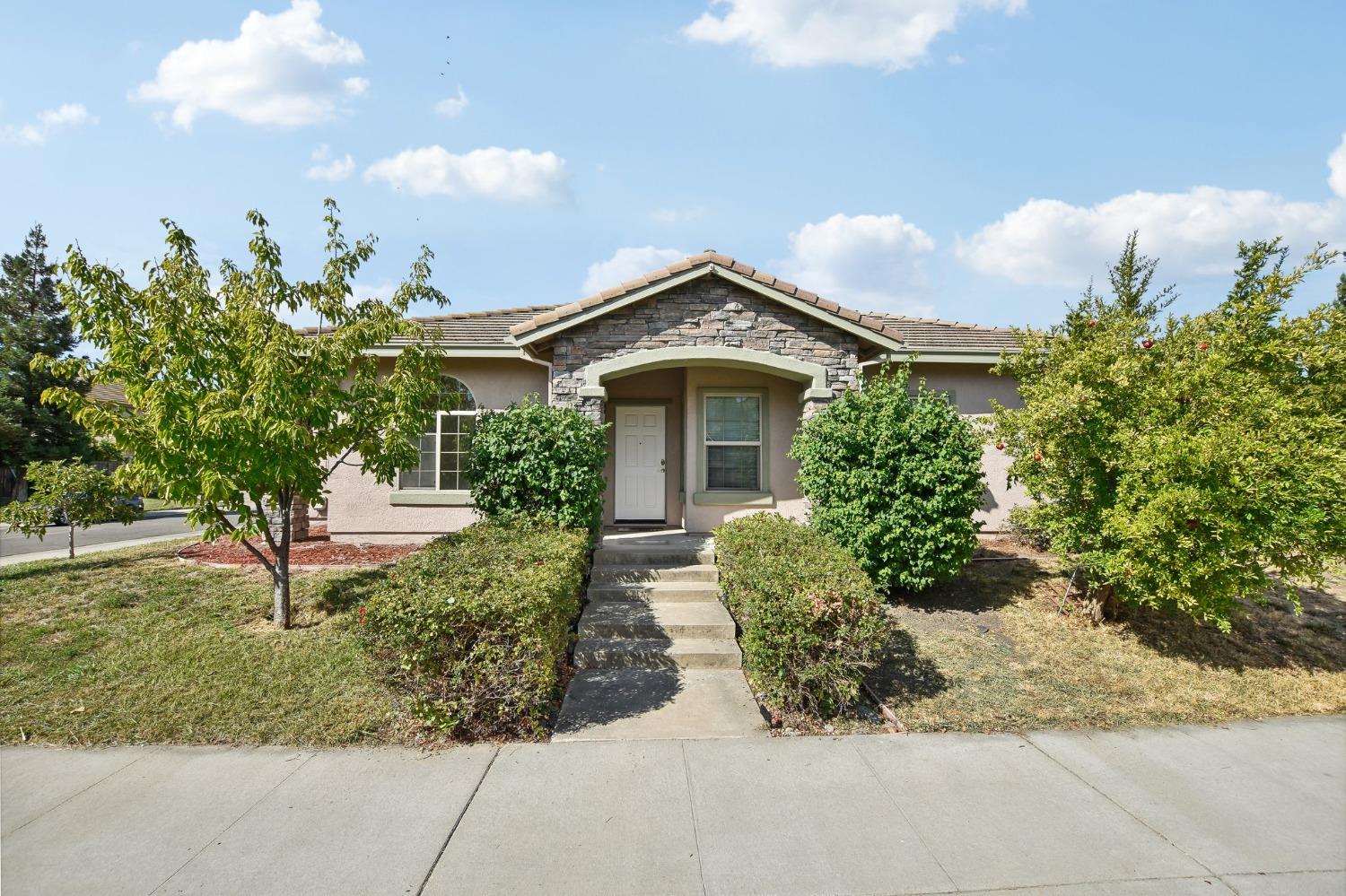 a front view of a house with a yard and fountain