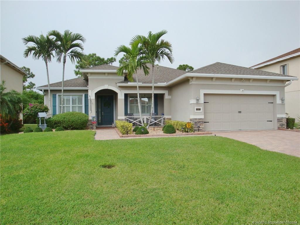 a front view of a house with a garden and yard