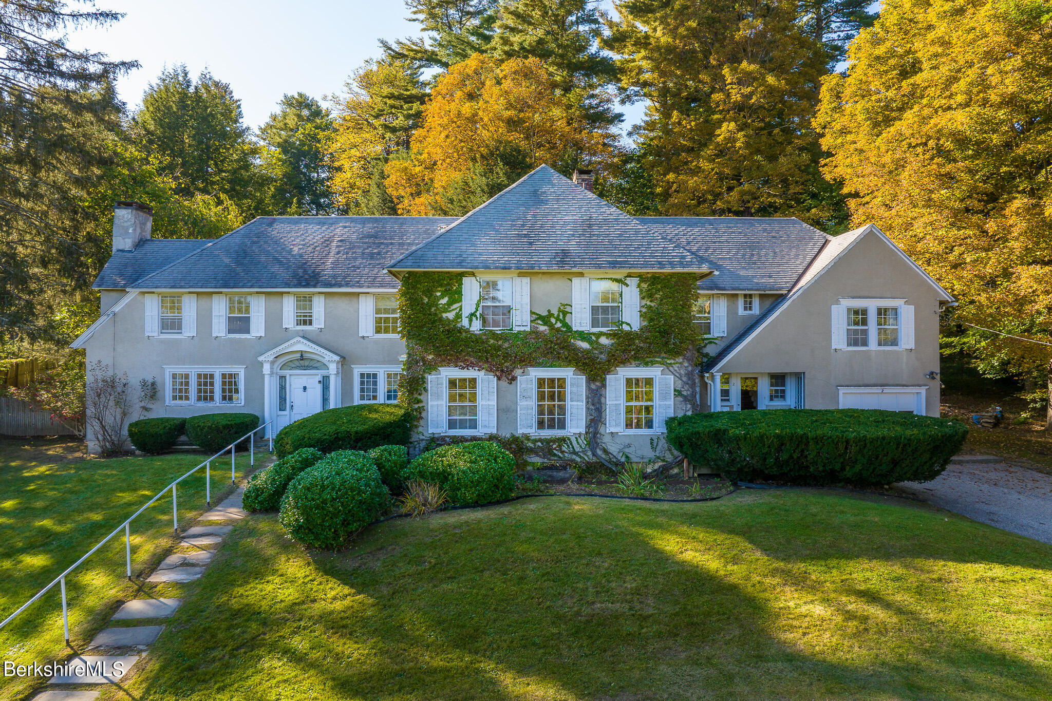 a front view of a house with a yard and green space