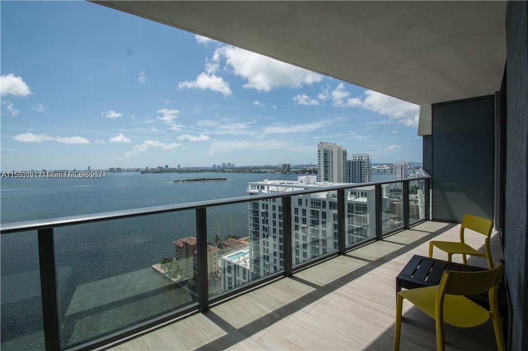 a view of a balcony with chair and wooden floor