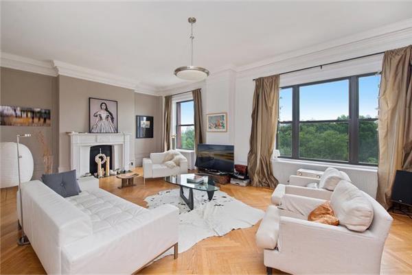 a living room with furniture a large window and a fireplace