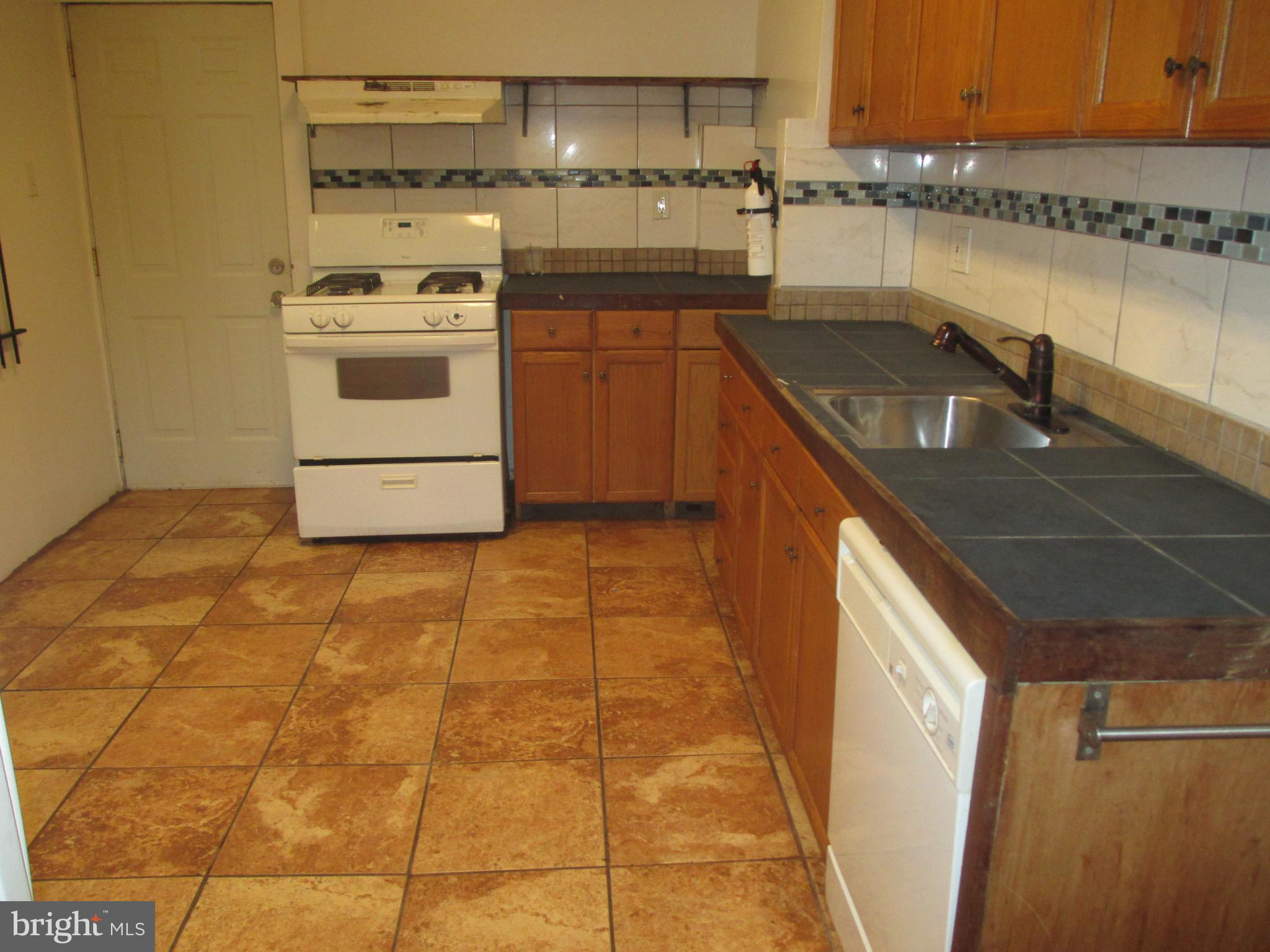 a kitchen with a sink a stove and cabinets