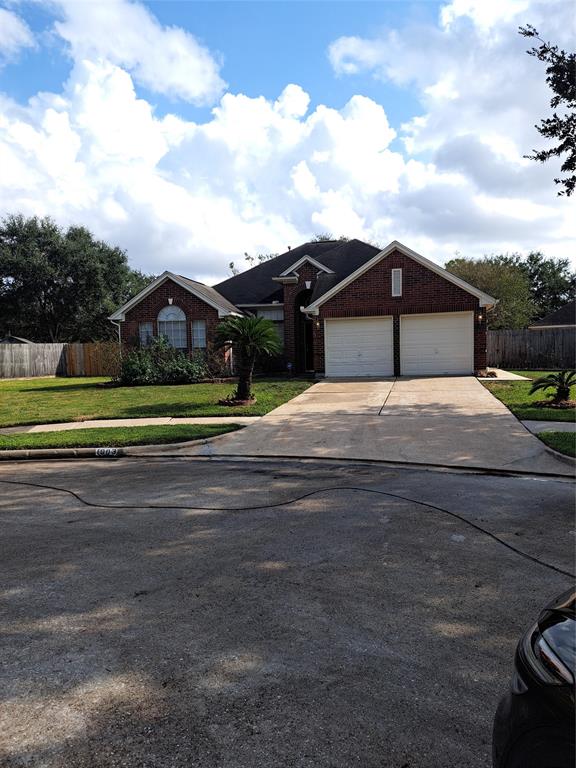 a white house with a yard and road