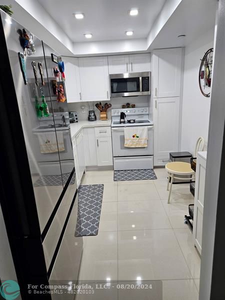 a kitchen with stainless steel appliances a refrigerator sink and microwave