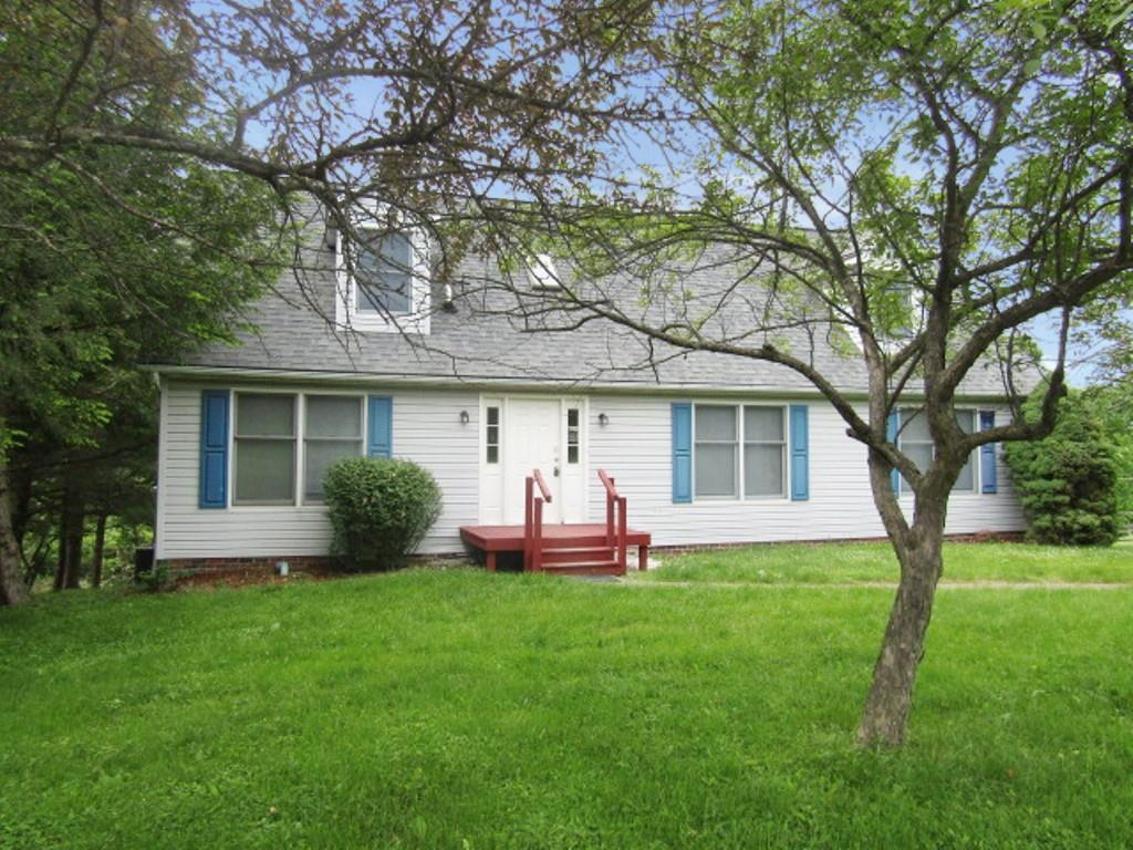 a front view of house with a garden and trees