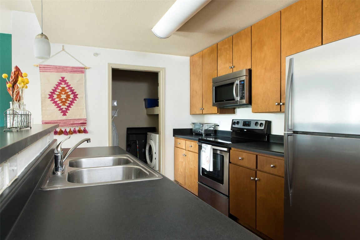 a kitchen with granite countertop a sink and a stove top oven