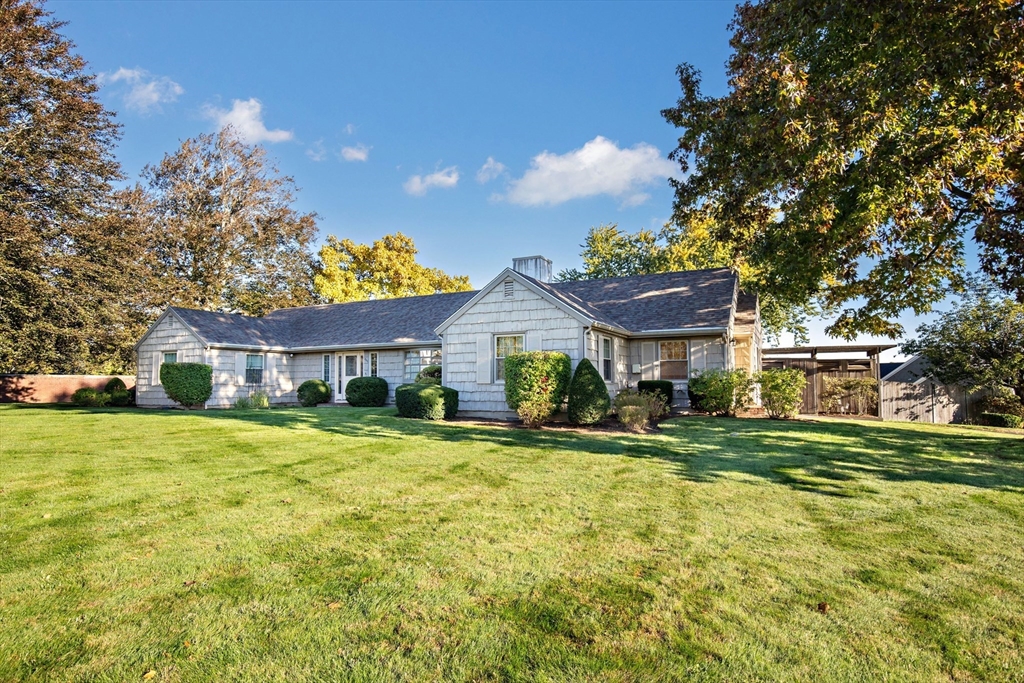 a view of a big house with a big yard and large trees