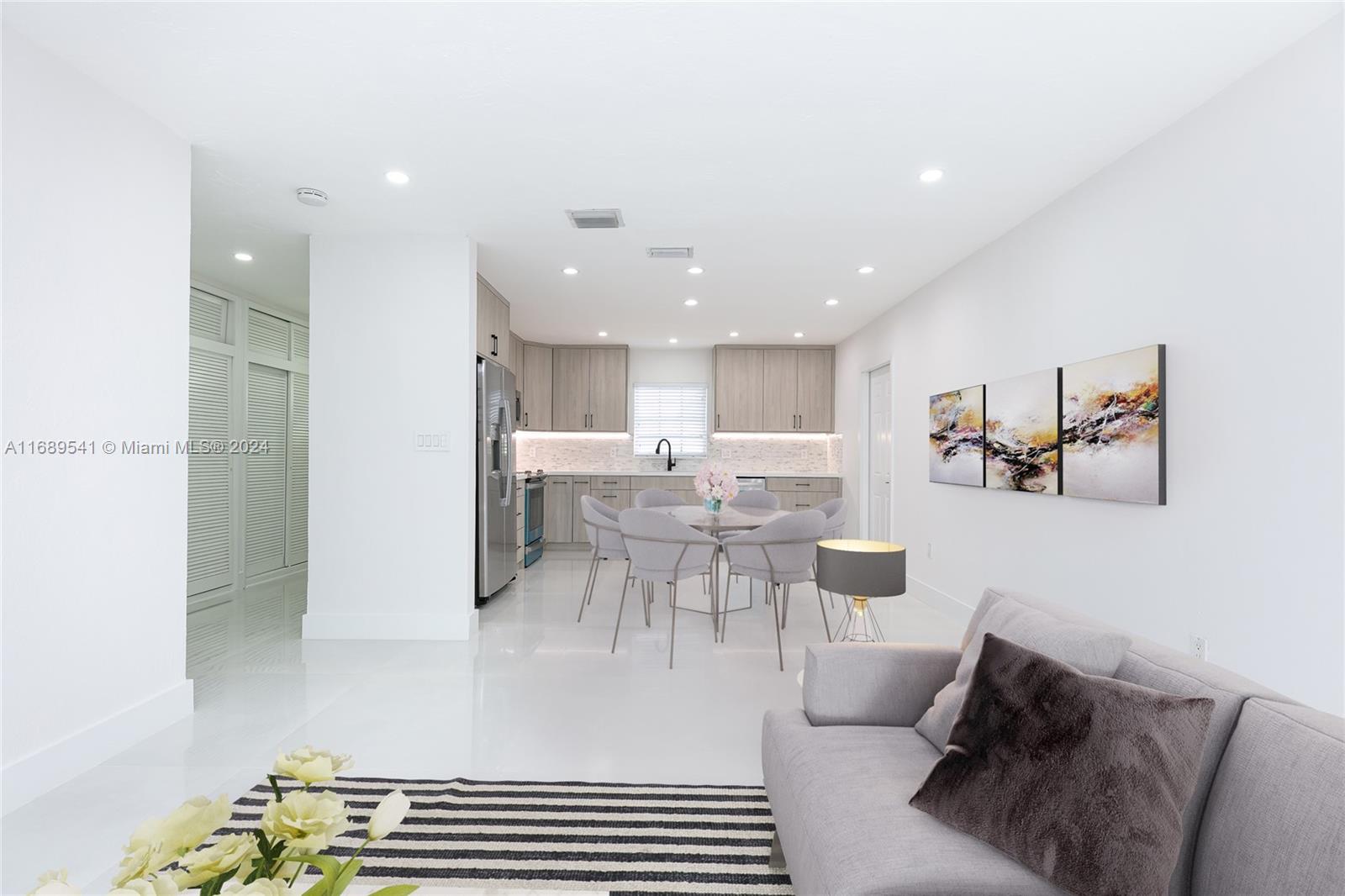 a living room with furniture and view of kitchen