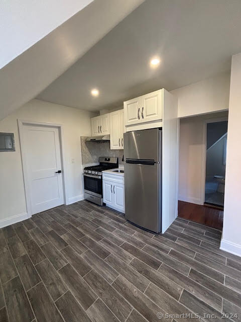 a large kitchen with a refrigerator and a stove top oven