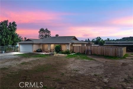 a view of a house with a yard and fence